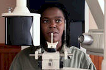 a person sitting in a dental chair getting their teeth cleaned
