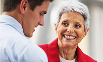 a man speaking with a smiling elderly woman