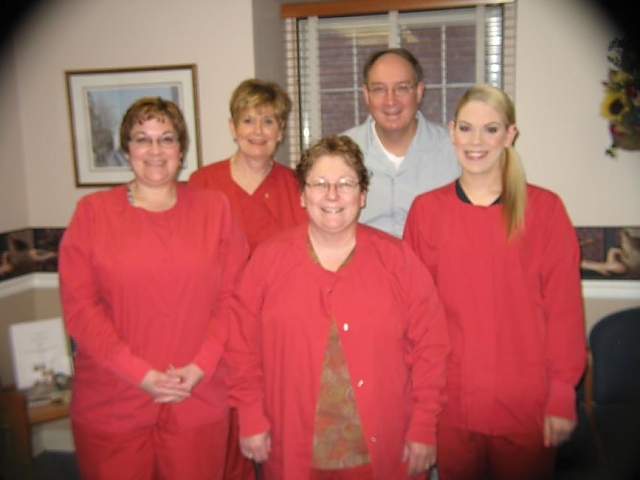 doctor cooper and four dental assistants dressed in red